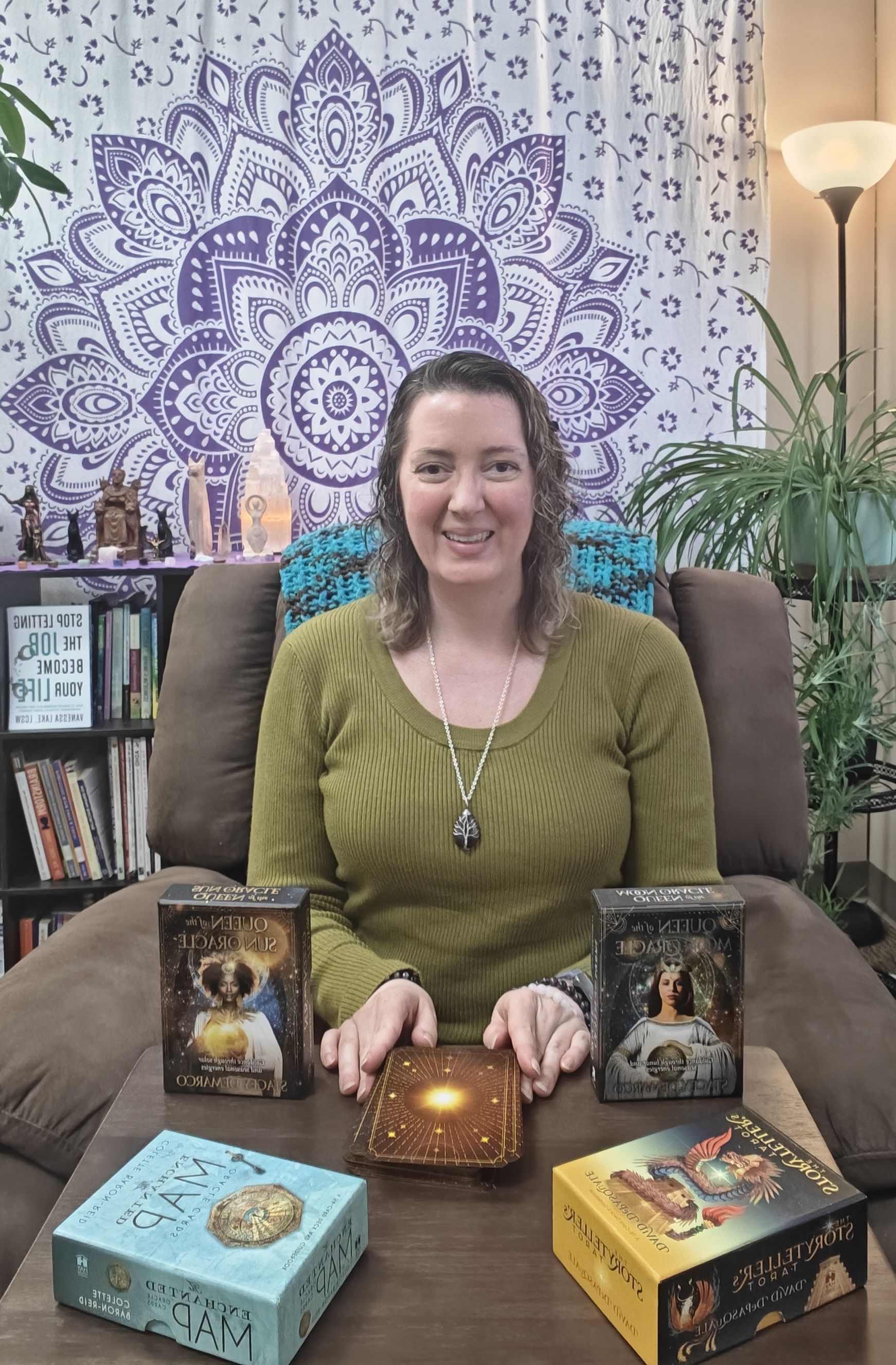 Vanessa in recliner chair with tarot and oracle card decks