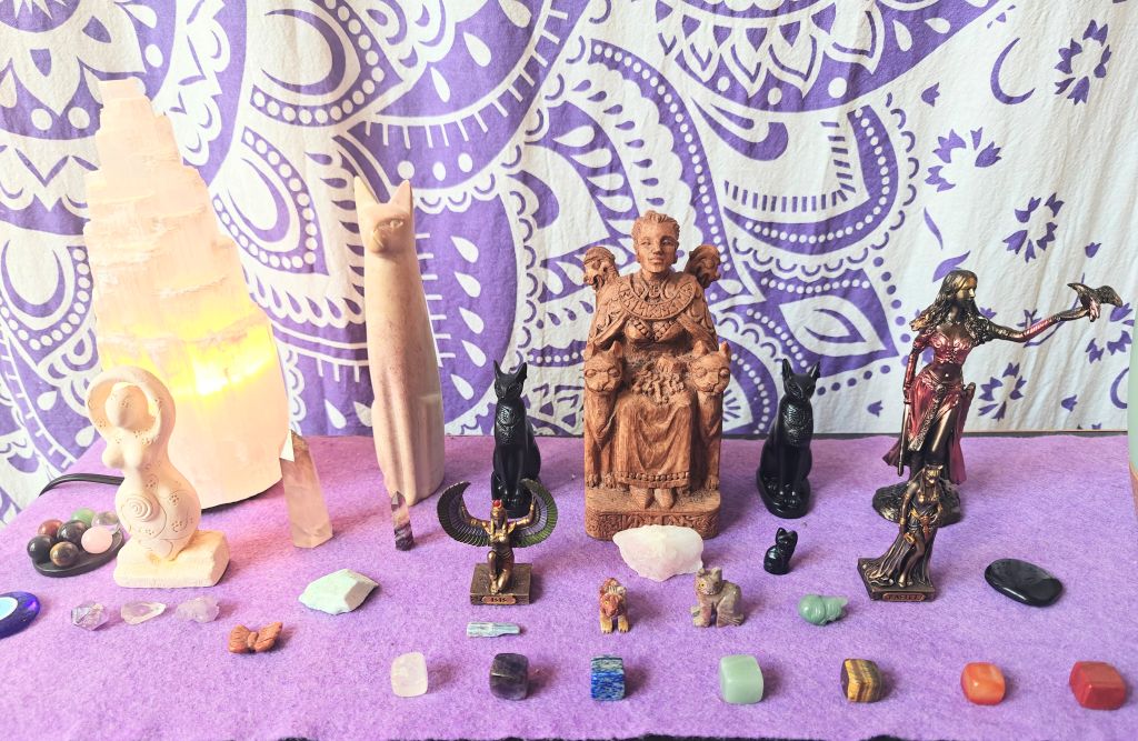 altar with crystals goddess statues and selenite tower lamp