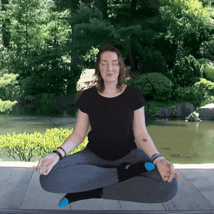 Vanessa sitting in meditation with images of chakra points