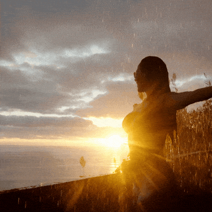 woman empowered standing in front of sunshine