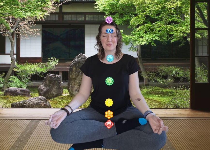 Vanessa sitting in meditation with images of chakra points
